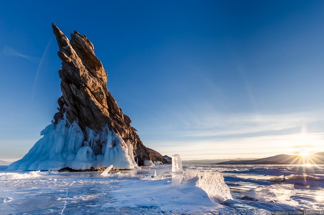 Солнце освещает лед Байкала у скалы острова Огой